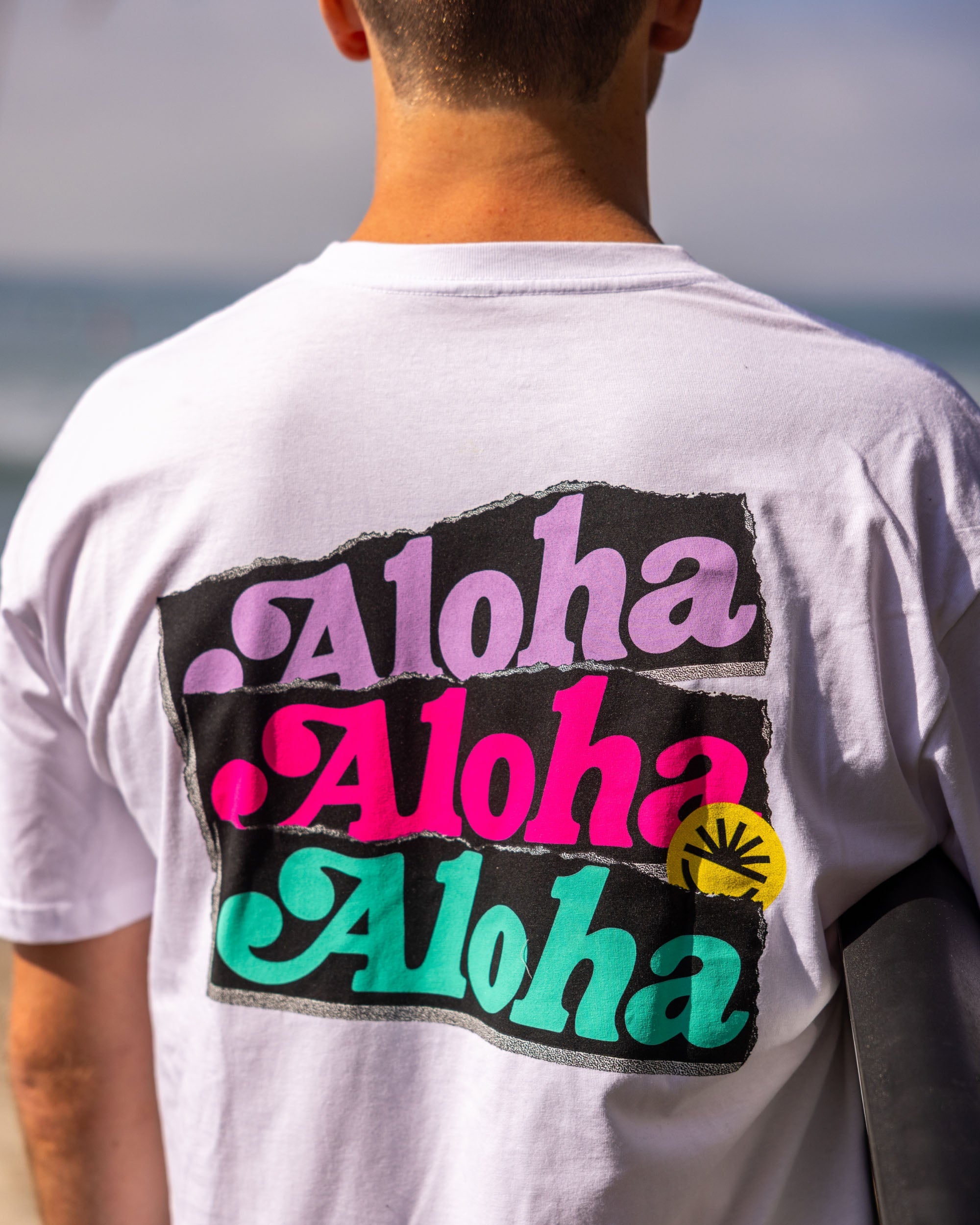 Fun Day Surf Aloha Tee in White back graphic close-up, lifestyle view