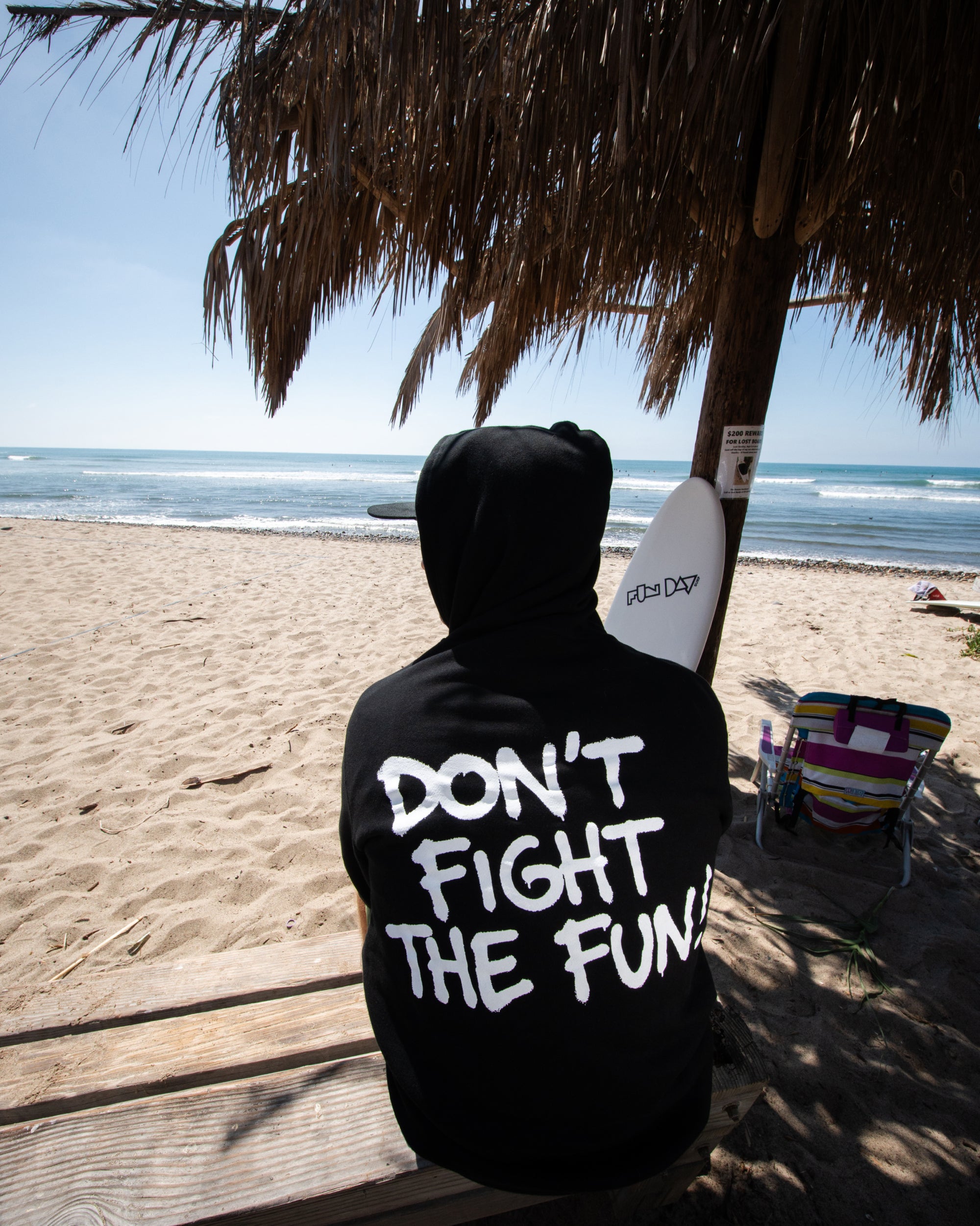 Fun Day Surf DFTF Hoodie in Black back graphic worn on the beach, lifestyle view