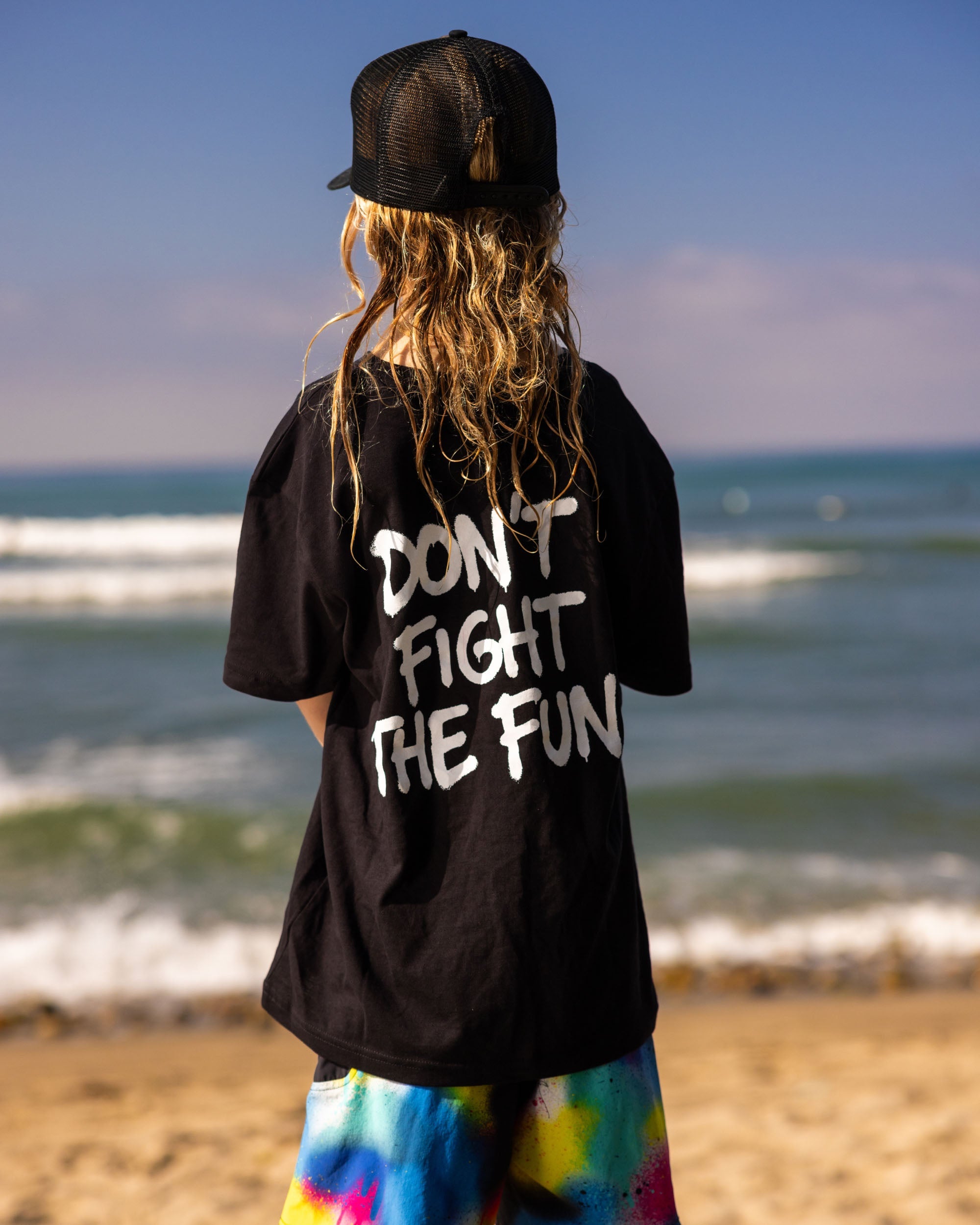 Fun Day Surf DFTF Youth Tee in Black back graphic worn at the beach, lifestyle view