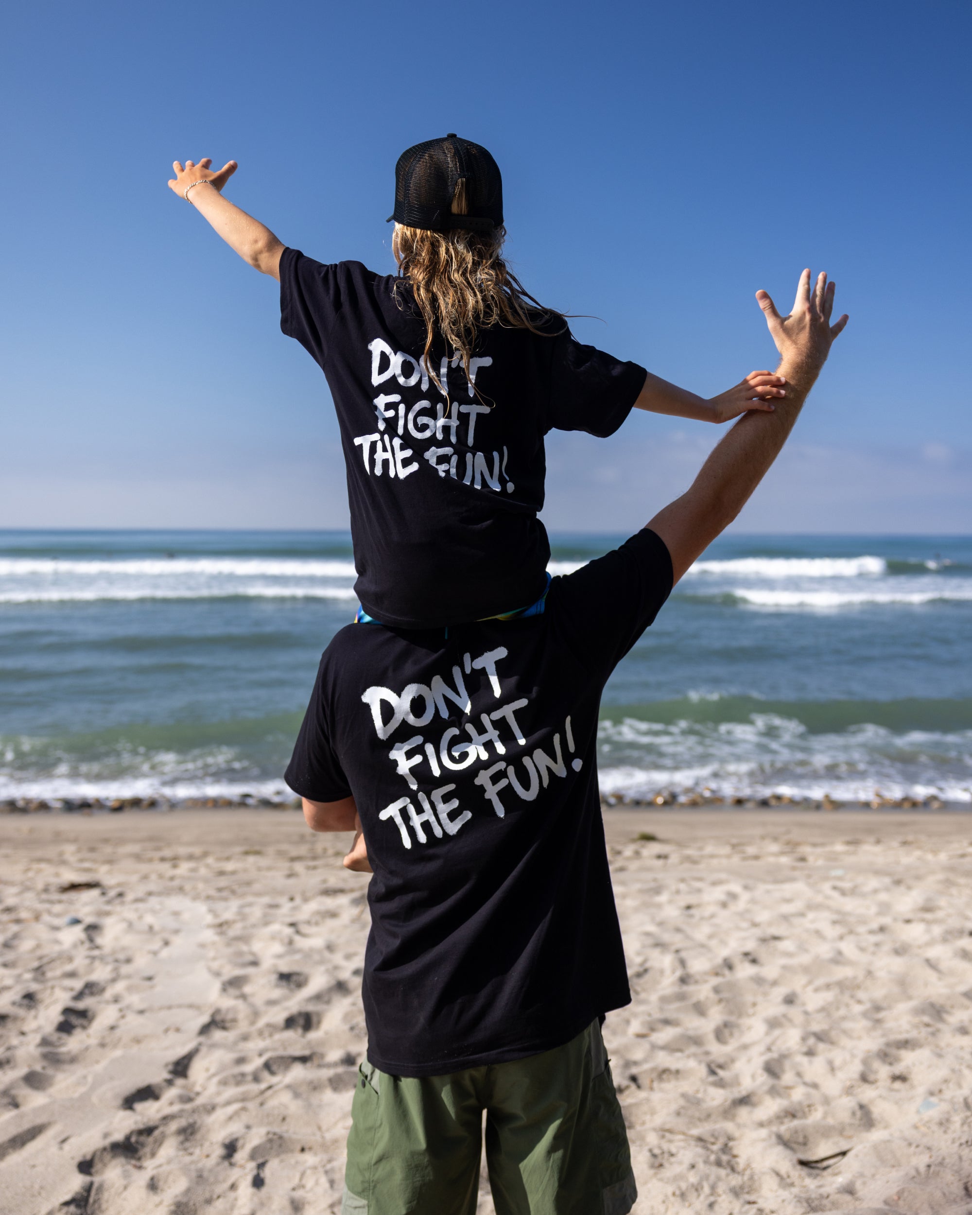 Fun Day Surf DFTF Youth Tee in Black back graphic worn at the beach, lifestyle view