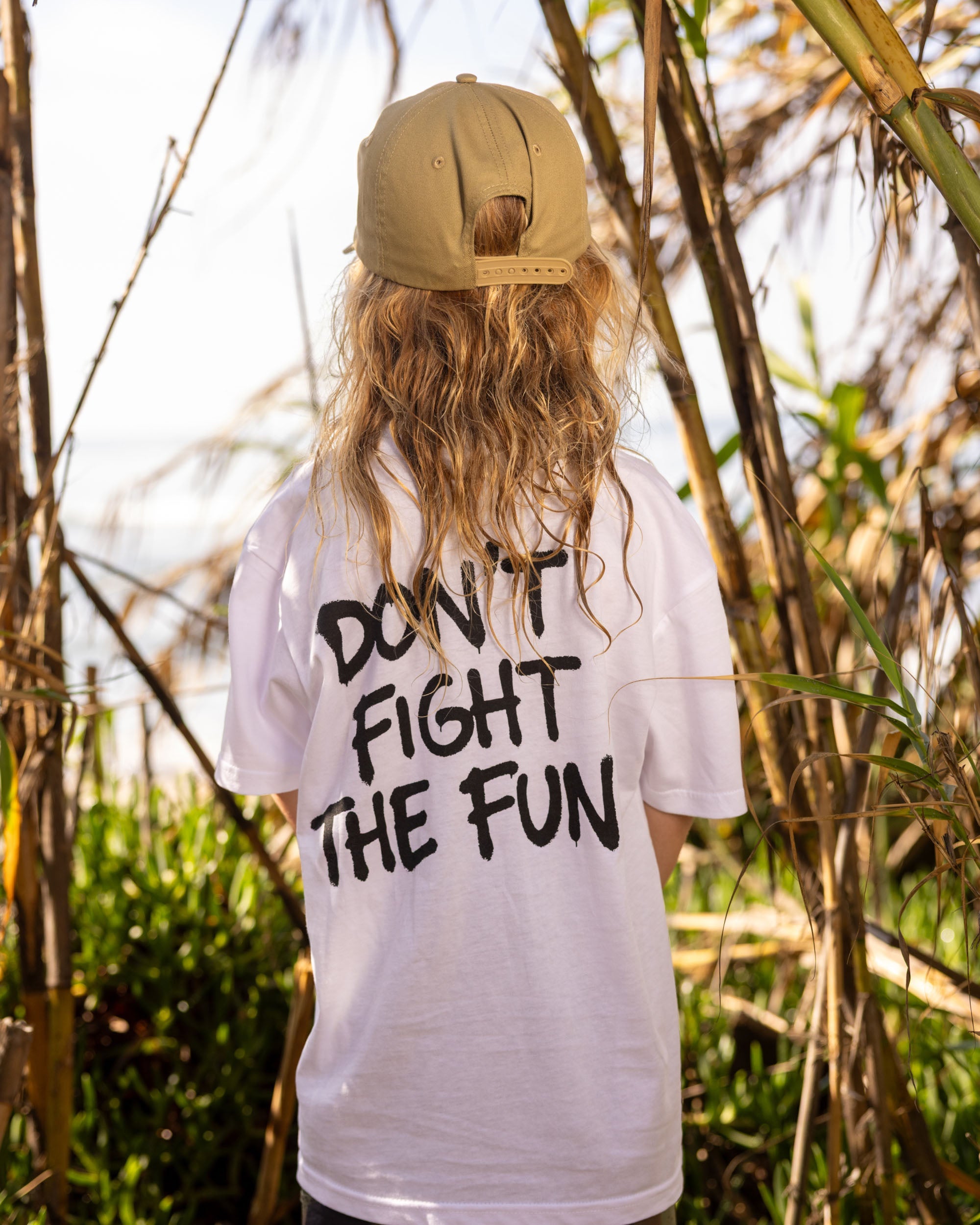 Fun Day Surf DFTF Youth Tee in White back graphic worn under the palms, lifestyle view