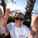 Fun Day Surf Framework Fill Tee in White worn under the palms, lifestyle view