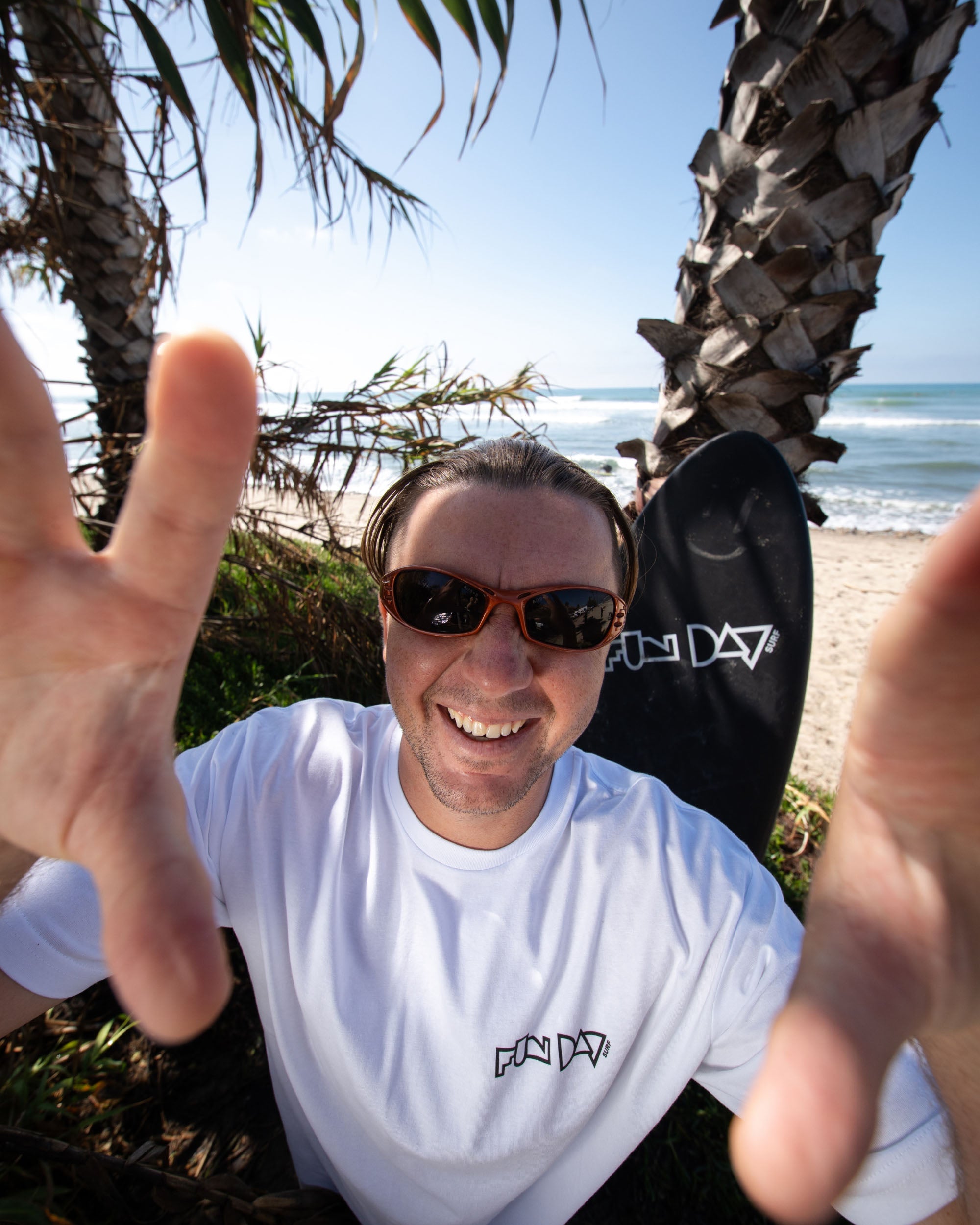Fun Day Surf Framework Fill Tee in White worn under the palms, lifestyle view