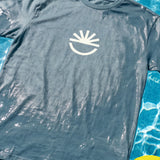 Fun Day Surf Fun Sun Tee in Seafoam laid flat by the pool, lifestyle view