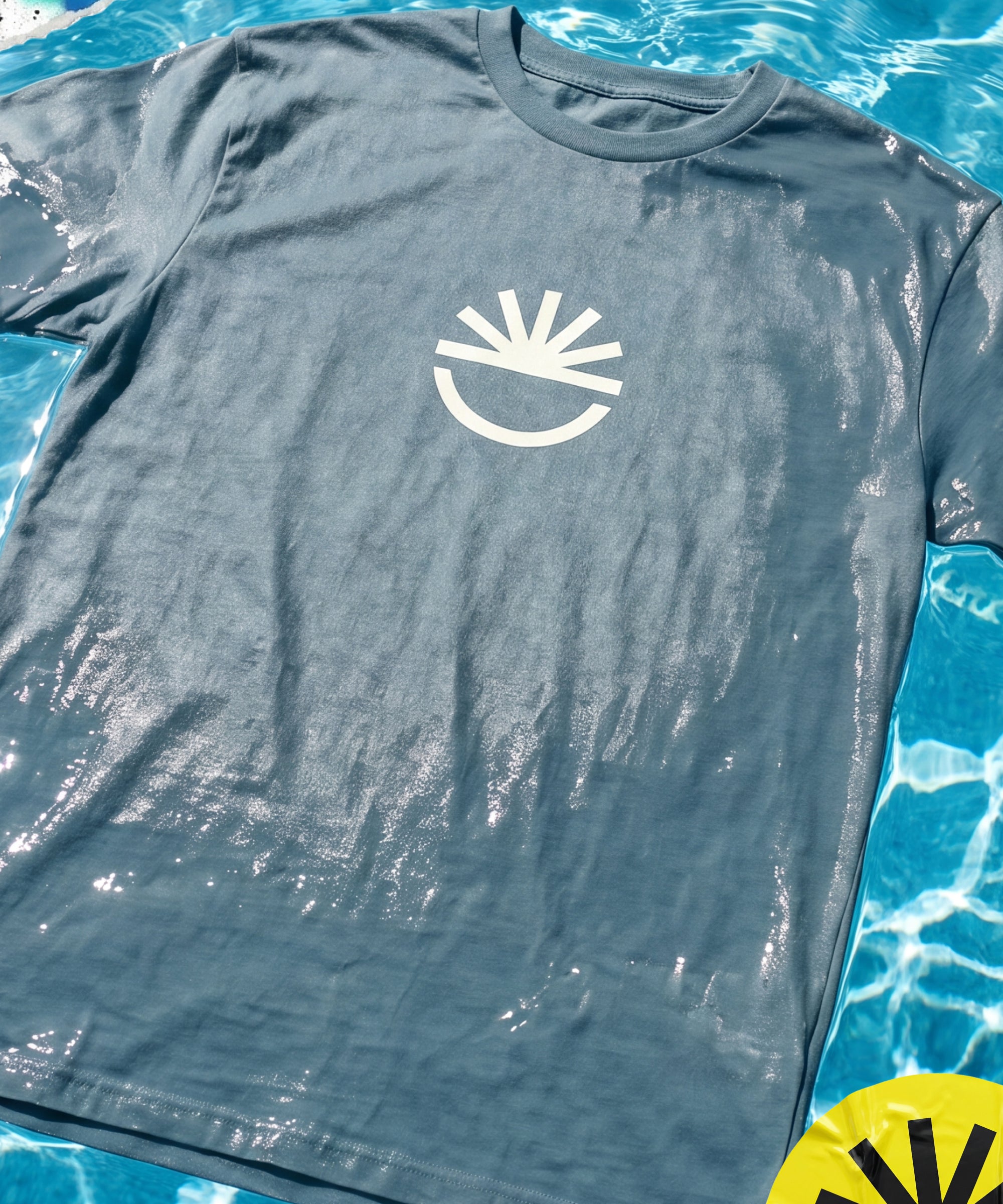 Fun Day Surf Fun Sun Tee in Seafoam laid flat by the pool, lifestyle view