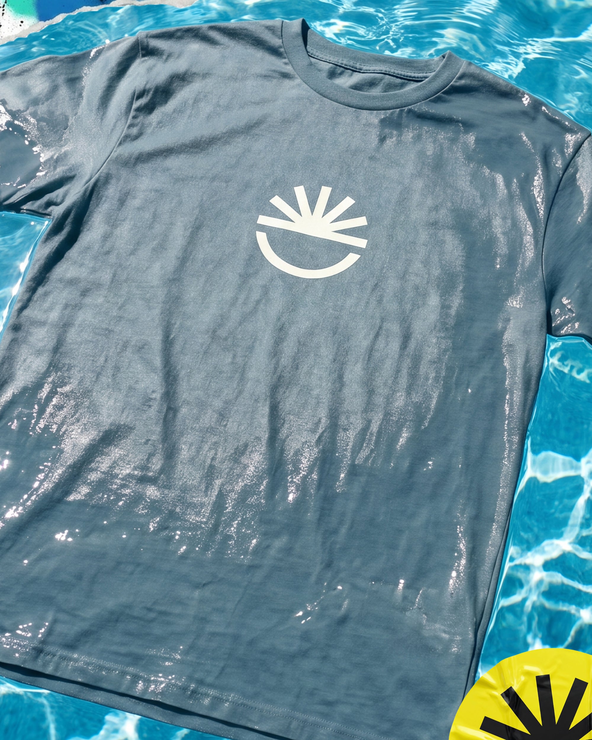 Fun Day Surf Fun Sun Tee in Seafoam laid flat by the pool, lifestyle view