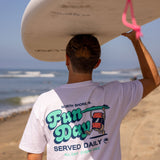 Fun Day Surf Musubi Tee in White back graphic worn carrying a surfboard, lifestyle view