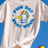 Fun Day Surf Stay Cool Tee in Vintage White back graphic against a blue sky, lifestyle view